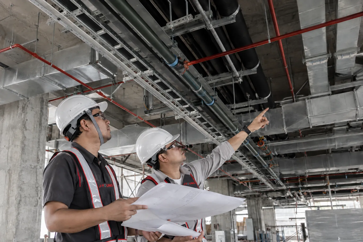 MEP engineers coordinating cable trays ductwork and piping on site